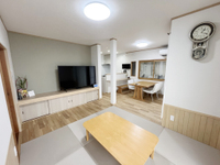 【改修後】地袋を増し張り、建具を作り替えています。壁は大壁としてキッチン・ダイニングと一体の空間になっても違和感がない様にしています。TVの背面壁はアクセントクロスとしましたが、畳の色も含めて全体的には張り替えた羽目板と調和する空間を意識しています